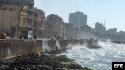 Las olas del mar rompen contra el muro del malecón habanero.