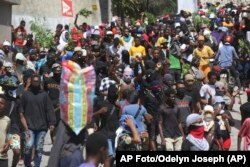 La gente protesta para que la policía y el Primer Ministro tomen medidas inmediatas contra las bandas en Puerto Príncipe, Haití, lunes 19 de agosto de 2024. (AP Foto/Odelyn Joseph)