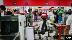 Foto de archivo. Funcionarios de Aduanas revisan el equipaje de los pasajeros en un escáner en el aeropuerto José Martí de La Habana. (Foto de ADALBERTO ROQUE / AFP)