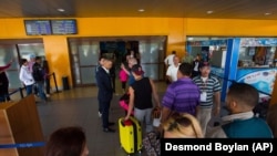 Cubanos hacen fila en el aeropuerto de La Habana. Foto: Desmond Boylan/AP.