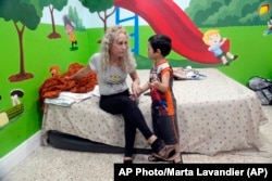 Daneilis Tamayo, migrante cubana, escucha a su hijo Daniel, de 3 años, en la iglesia Rescate de Hialeah, Florida