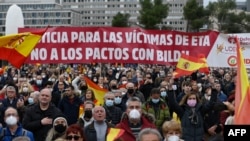 Manifestantes sostienen una pancarta en la que se lee "Justicia para las víctimas de ETA, no se pacta con Bildu", durante una manifestación organizada por la Asociación de Víctimas del Terrorismo (AVT). Plaza Colón de Madrid, el 26 de marzo de 2022. (Foto de OSCAR DEL POZO / AFP)