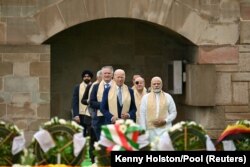 El presidente Joe Biden, con el primer ministro indio Narendra Modi, derecha, y otros líderes del G20 llegan para presentar sus respetos al Rajghat, un monumento a Mahatma Gandhi, en Nueva Delhi.