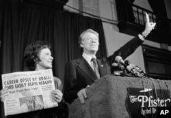 Jimmy Carter hace la señal de la victoria junto a su esposa, Rosalynn Carter, después de ganar la primaria presidencial demócrata de Wisconsin, en 1976. (AP Foto/Paul Shane, Archivo)