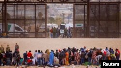 Foto Archivo. Migrantes se paran cerca del muro fronterizo después de cruzar el río Bravo con la intención de entregarse a los agentes de la Patrulla Fronteriza de los Estados Unidos. REUTERS: Jose Luis Gonzalez