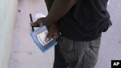 Un hombre sostiene su libreta de abastecimiento en una tienda del gobierno en La Habana. 