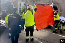 Paramédicos cubren la vista de una ambulancia estacionada en el lugar donde atienden al político derechista español Alejandro Vidal-Quadras tras ser baleado, en Madrid, el jueves 9 de noviembre de 2023.