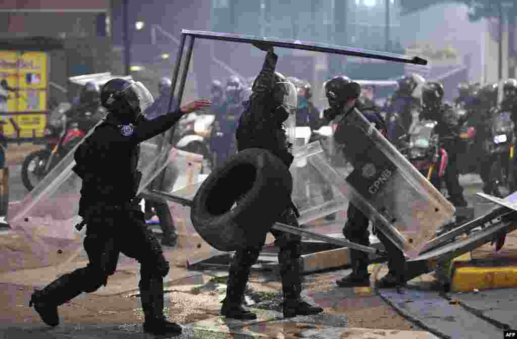 Agentes de policía retiran escombros durante protesta contra Nicolás Maduro en Caracas, el 29/07/2024. (Foto de Yuri CORTEZ / AFP)