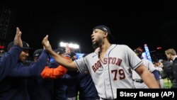 José Abreu (79), de los Astros de Houston, saluda a sus compañeros después de que el equipo derrotó a los Mellizos de Minnesota en el juego 4 para ganar la Serie Divisional de la Liga Americana de béisbol, en Minneapolis. (Foto AP/Stacy Bengs)