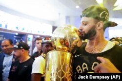 Jamal Murray, de los Denver Nuggets, besa el trofeo del campeonato de la NBA dentro del vestuario, después del triunfo del equipo sobre el Miami Heat. (AP/Jack Dempsey)