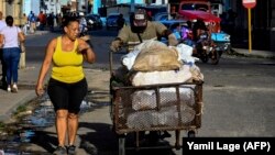 Un hombre empuja una carretilla con sacos de alimentos por una calle de La Habana. (Yamil Lage/AFP)