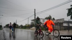 Foto de archivo.La gente se traslada en bicicleta y a pie bajo la lluvia antes de la llegada del huracán Ian en Coloma, Cuba, el 26 de septiembre de 2022. REUTERS/Alexandre Meneghini