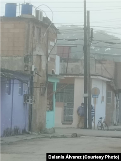 La esposa del preso político compartió esta imagen que muestra a dos hombres vestidos de civil en la esquina de su vivienda, a quien identifica como los vigilantes.