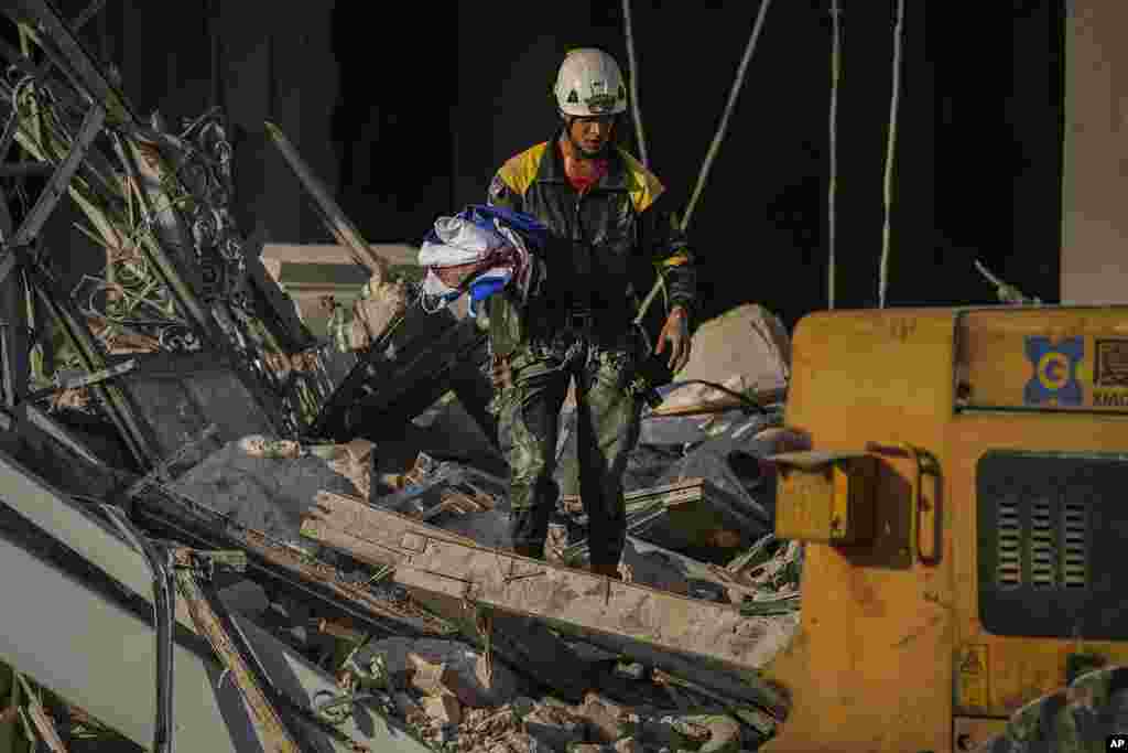 Un rescatista carga una bandera cubana recuperada en el lugar de una explosi&#243;n mortal que da&#241;&#243; el hotel Saratoga, en La Habana, el viernes 6 de mayo de 2022. (AP Foto/Ram&#243;n Espinosa)