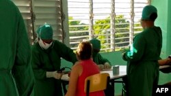 Pacientes en un centro de aislamiento de COVID-19, instalado en la escuela vocacional Lenin, en La Habana. (YAMIL LAGE / AFP)