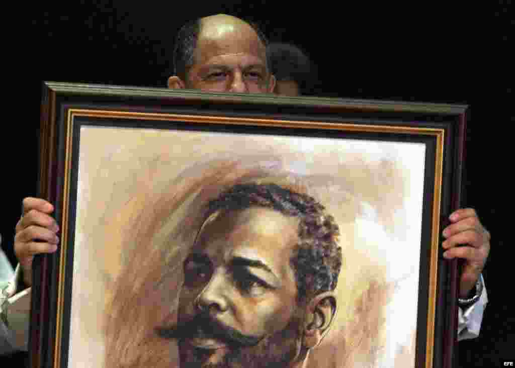 Luis Guillermo Solís (c) sostiene un retrato del prócer cubano Antonio Maceo.