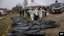 Forenses trasladan el cuerpo de un civil asesinado durante la guerra con Rusia tras sacarlo de una fosa común en Kyiv, Ucrania, el 8 de abril. (AP/Rodrigo Abd)