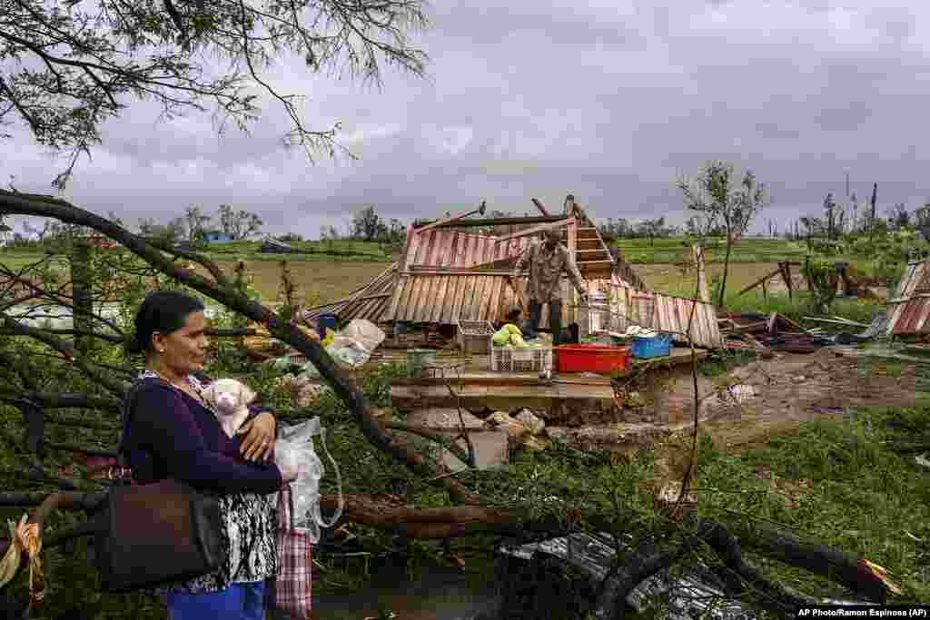 Mercedes Valdés sostiene a su perra Kira mientras espera el transporte después de perder su casa por el huracán Ian en Pinar del Río, Cuba, el martes 27 de septiembre de 2022. (Foto AP/Ramon Espinosa)