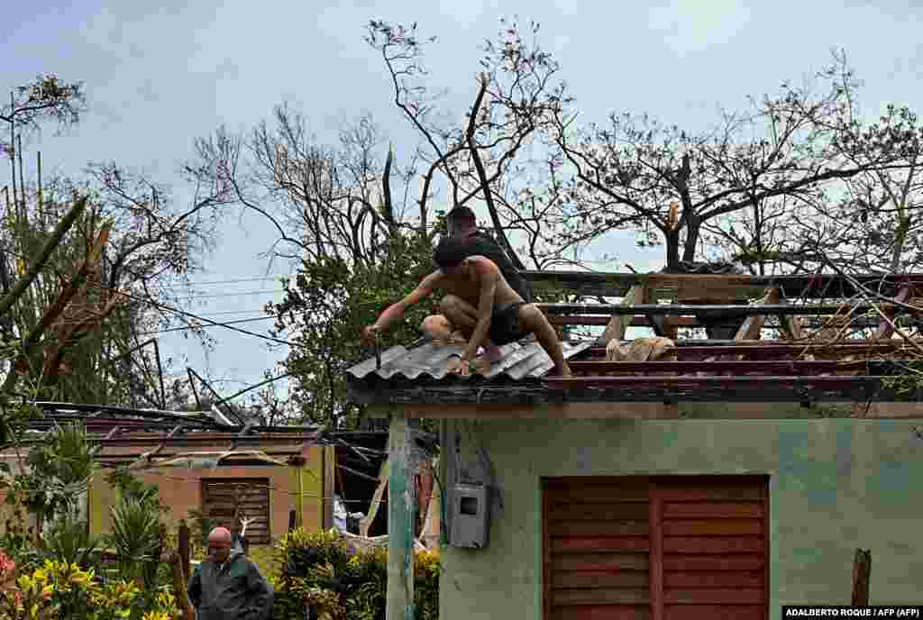 Cubanos reparan un techo en San Juan y Martínez, provincia de Pinar del Río, el 27 de septiembre de 2022 tras el paso del huracán Ian.