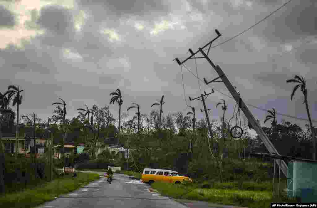 Postes de luz caídos bordean una calle después de que el huracán Ian azotara Pinar del Río, Cuba, el martes 27 de septiembre de 2022.