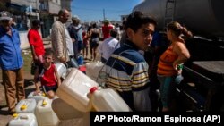 Residentes de La Coloma en busca de agua potable, tras el paso del huracán Ian.