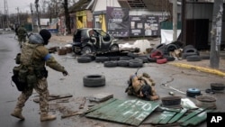 Militares rusos comprueban las calles por si hubiera trampas explosivas en Bucha, un suburbio de Kiev que estuvo ocupado por tropas rusas, el sábado 2 de abril de 2022. (AP Foto/Vadim Ghirda)