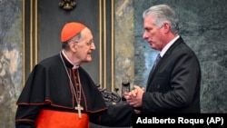 Miguel Díaz-Canel, a la derecha, habla con el cardenal Beniamino Stella durante una ceremonia en la Universidad de La Habana para conmemorar el 25to aniversario del viaje apostólico de San Juan Pablo II a Cuba. (Adalberto Roque/AP)