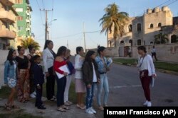 Varias personas esperan en una fila para entrar a la embajada de Estados Unidos.