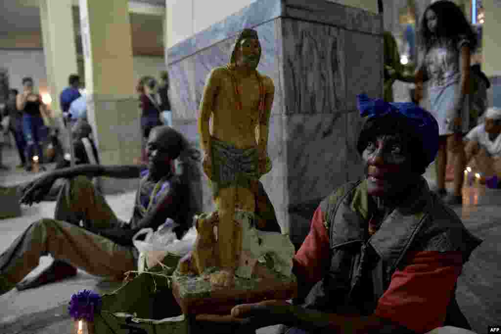 Un peregrino lleva una estatuilla de Babal&#250; Ay&#233;, la imagen sincr&#243;nica de San L&#225;zaro en los ritos afrocubanos. Yamil Lage/AFP