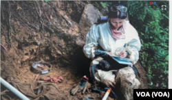 Antropóloga forense de la Unidad de Búsqueda toma una dentadura postiza encontrada en selvas y bosques donde se ocultaron cuerpos de personas desaparecidas. Esta imagen de 2022 es parte de la exhibición presentada en el Instituto de la Paz de EEUU.