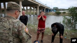 Migrantes cubanos interceptados por agentes de la Guardia Nacional estadounidense tras cruzar a nado el Río Bravo, en Eagle Pass, Texas. (AP/Dario Lopez-Mills)