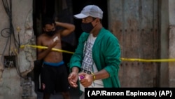 Un trabajador de la salud desinfecta sus manos en frente de una casa en cuarentena, en La Habana. ( AP/Ramon Espinosa)