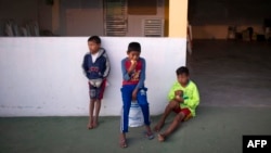 Niños toman su desayuno en las afueras de una iglesia en la frontera con Brasil. 