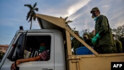 Militares movilizados por el gobierno cubano llegan el miércoles a una plaza de La Habana para desinfectar el área (Foto: Yamil Lage/AFP).