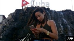 Una cubana chequea su teléfono móvil en una calle de La Habana. El vertical se ha convertido en un formato cada vez más popular en diferentes géneros cinematográficos. 