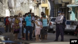 Desde que las abrieron el 20 de julio, cuando fue tomada esta foto, las tiendas que venden alimentos y artículos de primera necesidad en dólares han tenido largas colas custodiadas por policías y militares (Adalberto Roque/AFP).