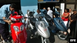 Cubanos observan distintos modelos de motos eléctricas en un centro comercial en La Habana. (Archivo)