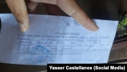 Yasser Castellanos muestra el documento de la citación.