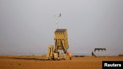 Un soldado israelí vigila una batería de interceptor de cohete Iron Dome desplegada cerca del centro de la Franja de Gaza.