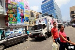 Dos personas cruzan por una calle de la Zona Libre de Colón.