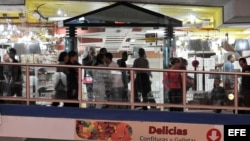 Varias personas caminan en un centro comercial Carlos III.