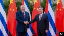 El premier cubano Manuel Marrero saluda a su homólogo chino Li Qiang antes de una reunión en Shanghai, el 4 de noviembre de 2023 (Zhai Jianlan/Xinhua vía AP)