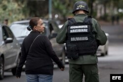 Aura Perez (i), tía de Oscar Pérez, habla con uno de los militares que custodian la morgue.