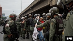 Militares retiran a una mujer que bloqueaba el paso de una tanqueta de la Guardia Nacional durante una manifestación. Foto Archivo