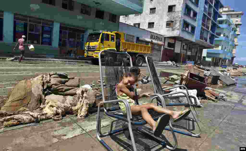 Una niña descansa fuera de su casa el11 de septiembre del 2017, después del paso del huracán Irma por La Habana (Cuba)