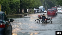 Un hombre conduce una motocicleta por una calle inundada el miércoles en La Habana.