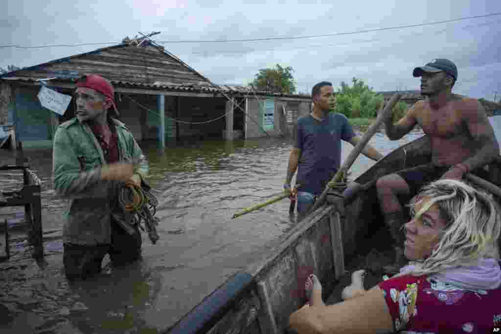 Vecinos conversan en una calle inundada tras el paso del huracán Helene en Guanimar, provincia de Artemisa, Cuba, el miércoles 25 de septiembre de 2024. (Foto AP/Ramon Espinosa)