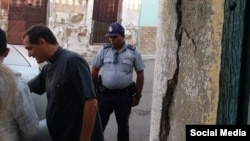 El sacerdote católico Castor Álvarez interpela a la policía ante la detención del periodista independiente Henry Constantín. (Facebook).