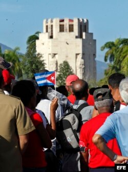 Varias personas esperan cerca de la entrada del cementerio Santa Ifigenia.