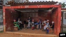 Niños toman un descanso entre juego y juego de pelota. 